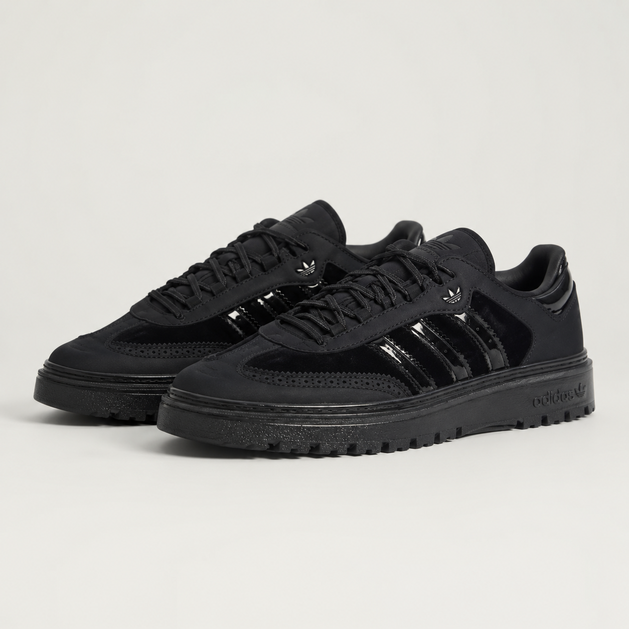 adidas Originals low trainer in core black nubuck with glossy three stripes, angled pair view